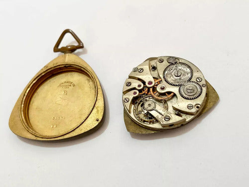 Antique pocket watch parts including an opened gold-tone case and intricate internal mechanical gears and components.